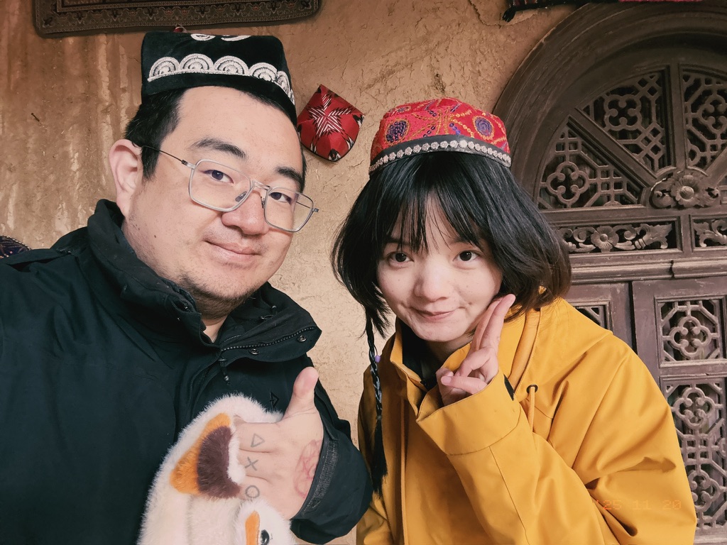 有一面墙上挂着很多顶维族小帽，我们取下来拍了个认证照