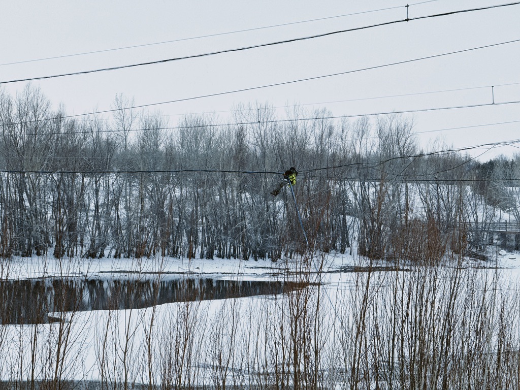 电力工人在冰雪天依旧要高空作业