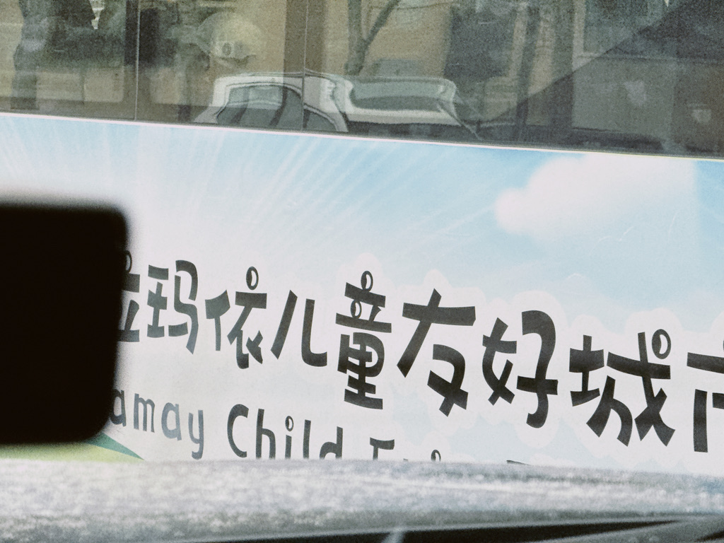 来的路上大巴车身上的广告「克拉玛依儿童友好城市」