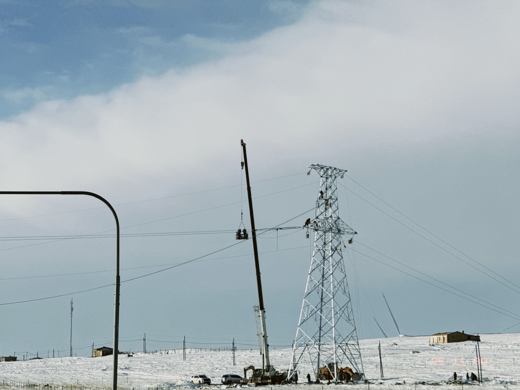 在冰雪之中高空作业的电力工人