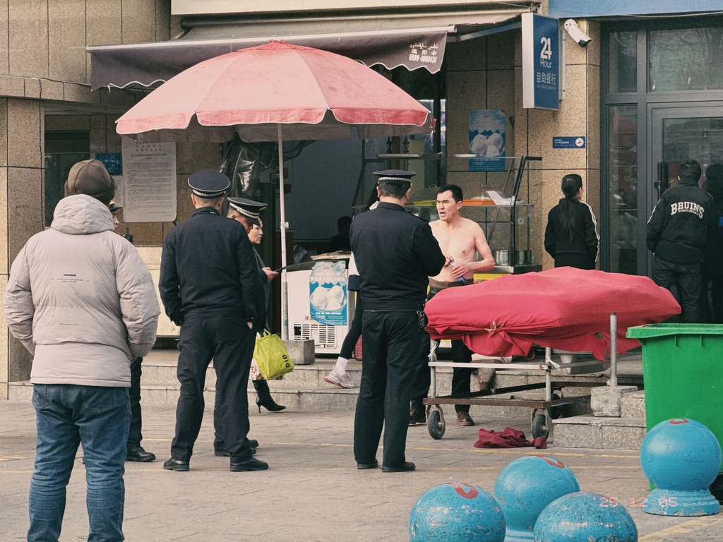 楼下的小摊贩不知为何与城管对峙起来