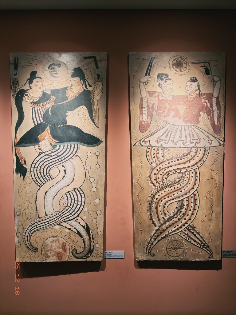 伏羲女娲图，左侧为汉风，右侧为胡风，但都得蛇缠在一起