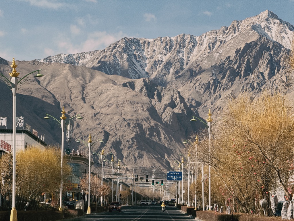 塔县的街道在高入云霄的山峰下，人不由自主地谦卑起来