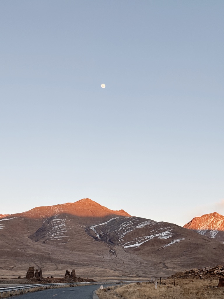 月亮、夕阳与山下的废弃建筑