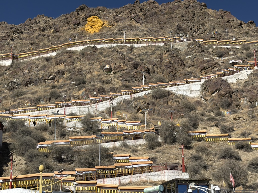 回头望走下来的转经路，风吹白色布帘有如海浪一般，非常美丽