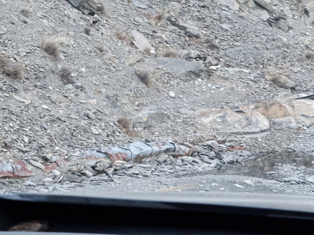 看到路边完全被落石压扁的，不知道是什么的运输管道