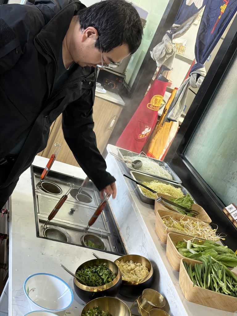 早晨食堂里有自助的煮面锅，毛师傅带病煮面，味道还不错