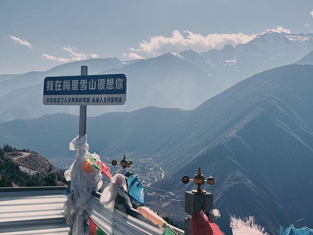 哪里都躲不开的通俗牌子，背后山脚下的是斯农村