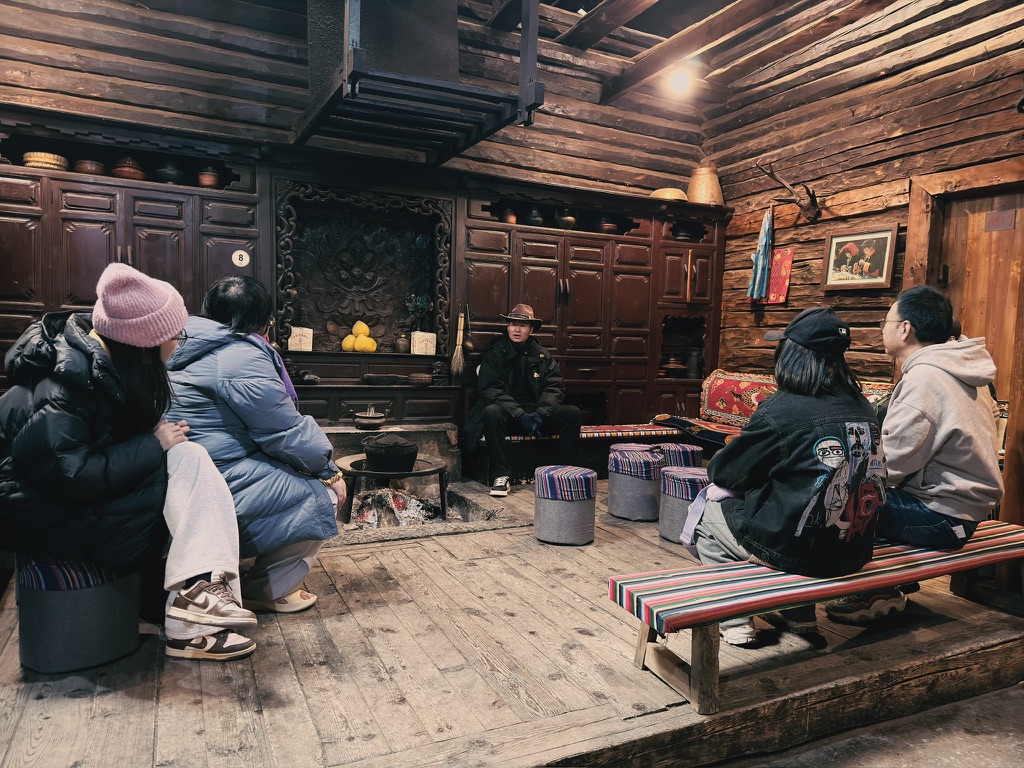 讲解的摩梭人大叔，在摩梭人的传统住房里