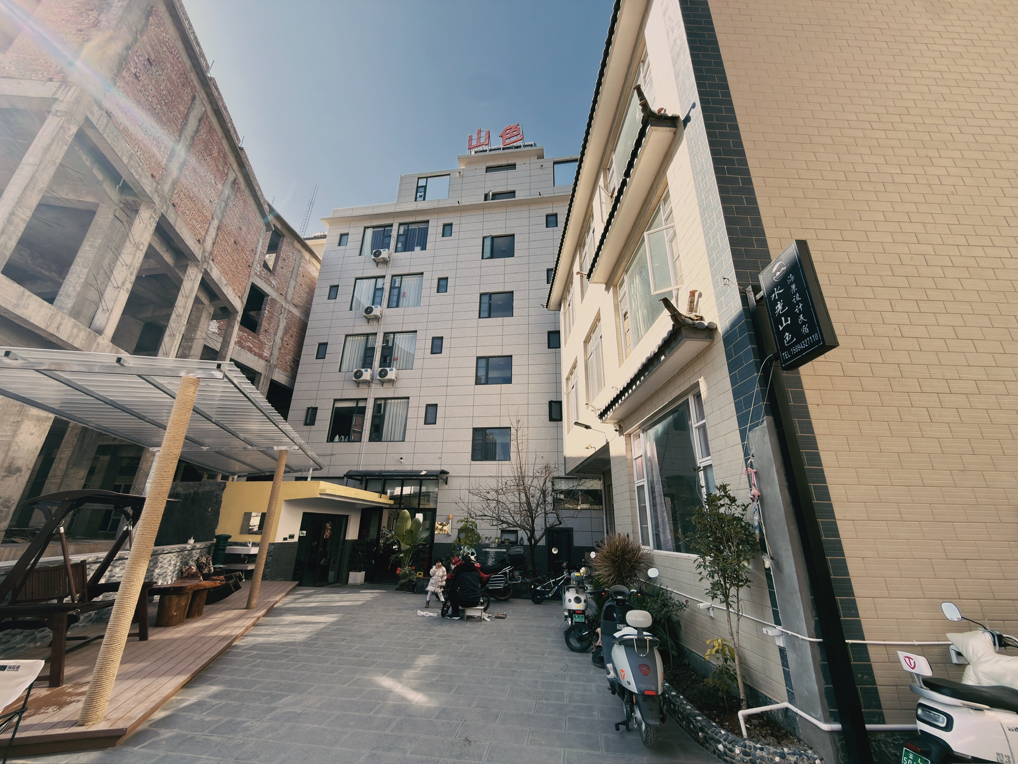 老板家人住右面的楼，正面的楼是民宿，民宿左下角的是理发店，而左侧的新楼不知道是不是也是他家新盖的