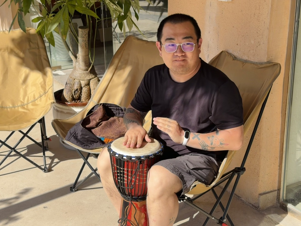 坐在店门口敲手鼓的毛