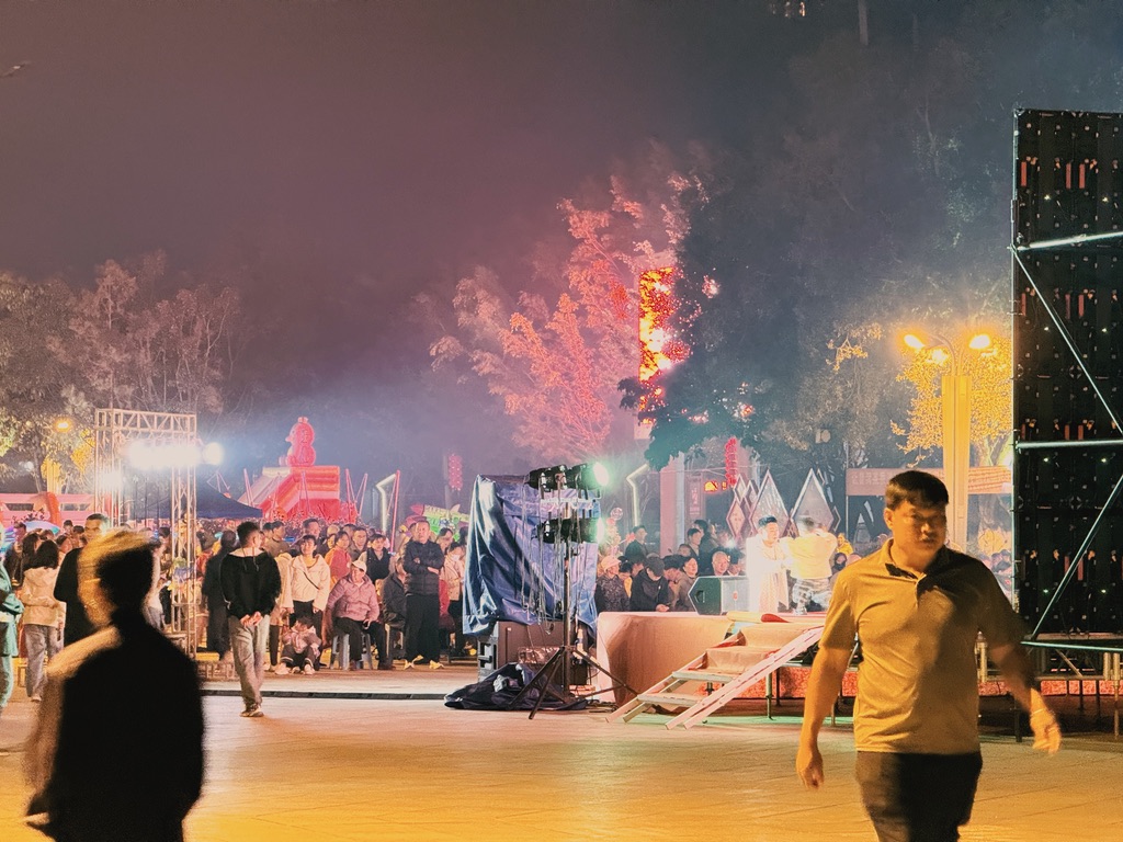现场有一个大舞台,很多人聚集在那里等待演出