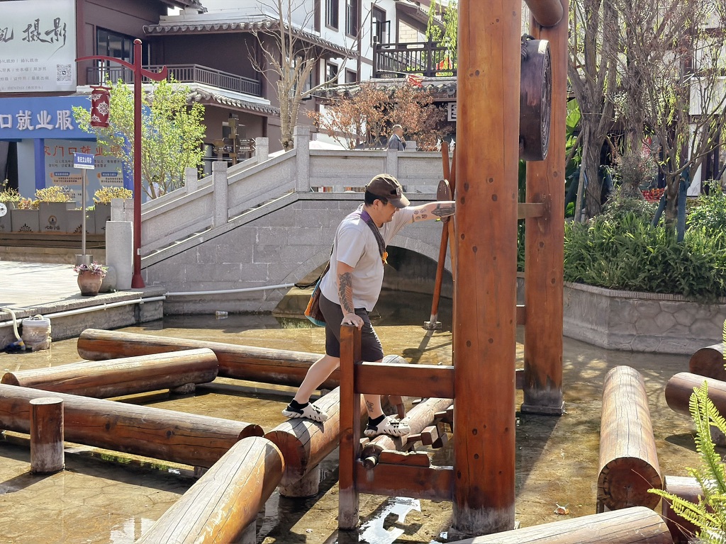 古镇里有一个脚踏水车，我从滚木（其实是固定住的）间穿梭，到了上面