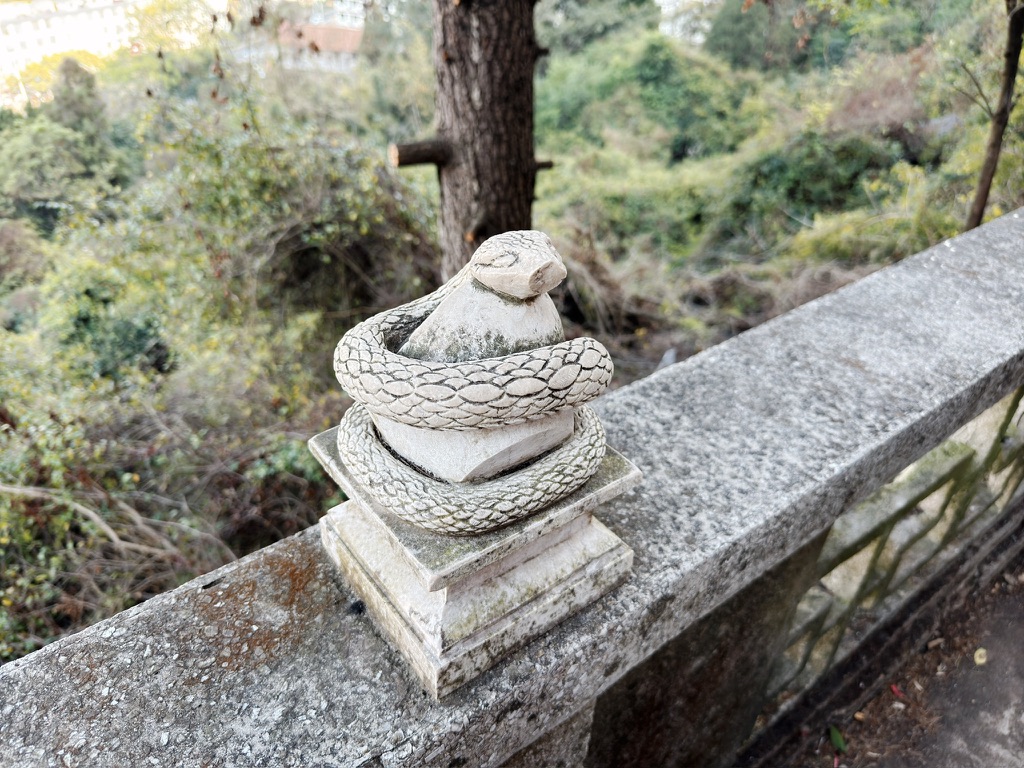 围栏上有十二生肖的雕像，但都被人破坏得缺胳膊少腿，这蛇也少了鼻子