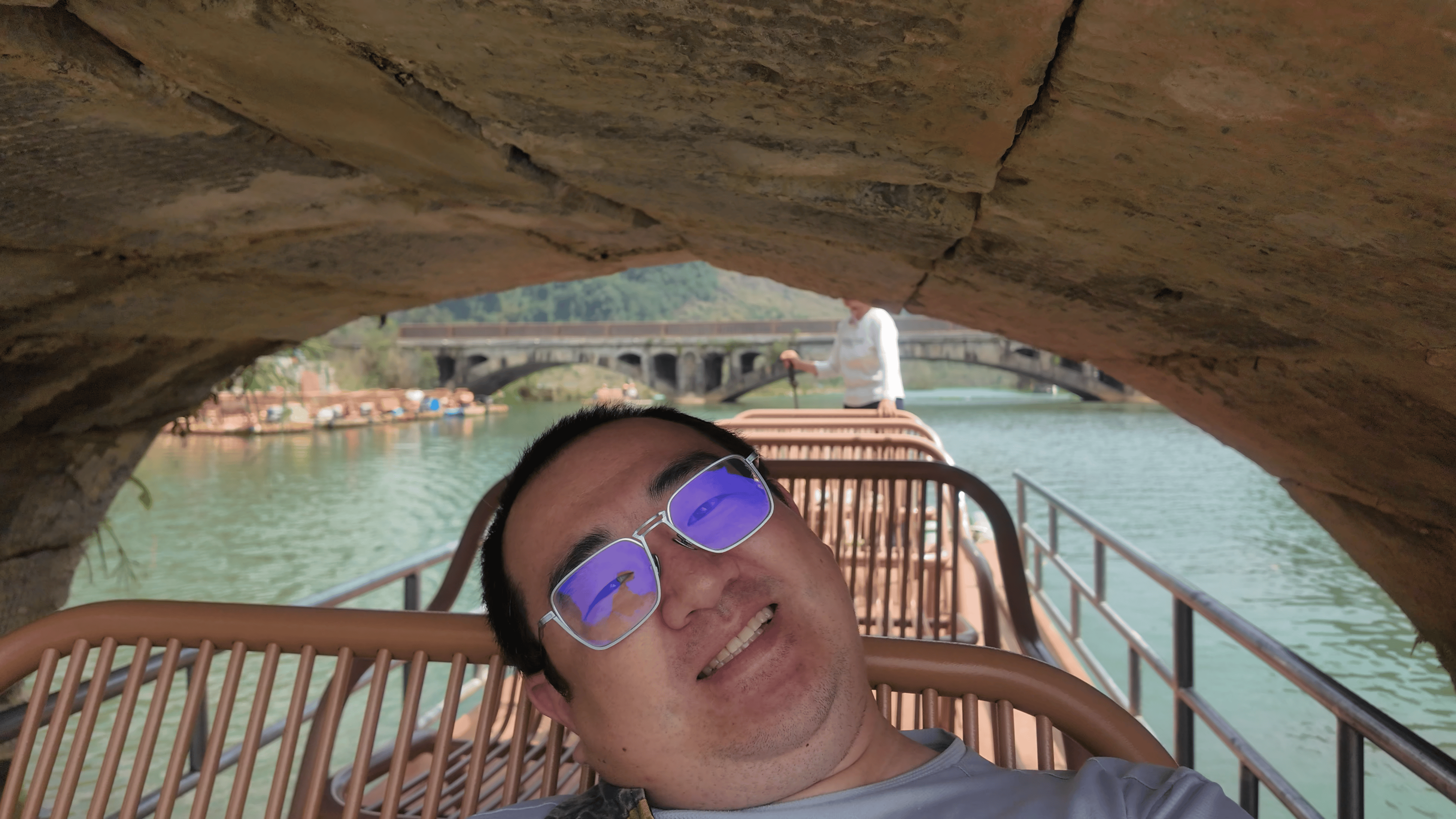 石桥非常低，竹筏从下面穿过的时候，所有人都需要趴下。