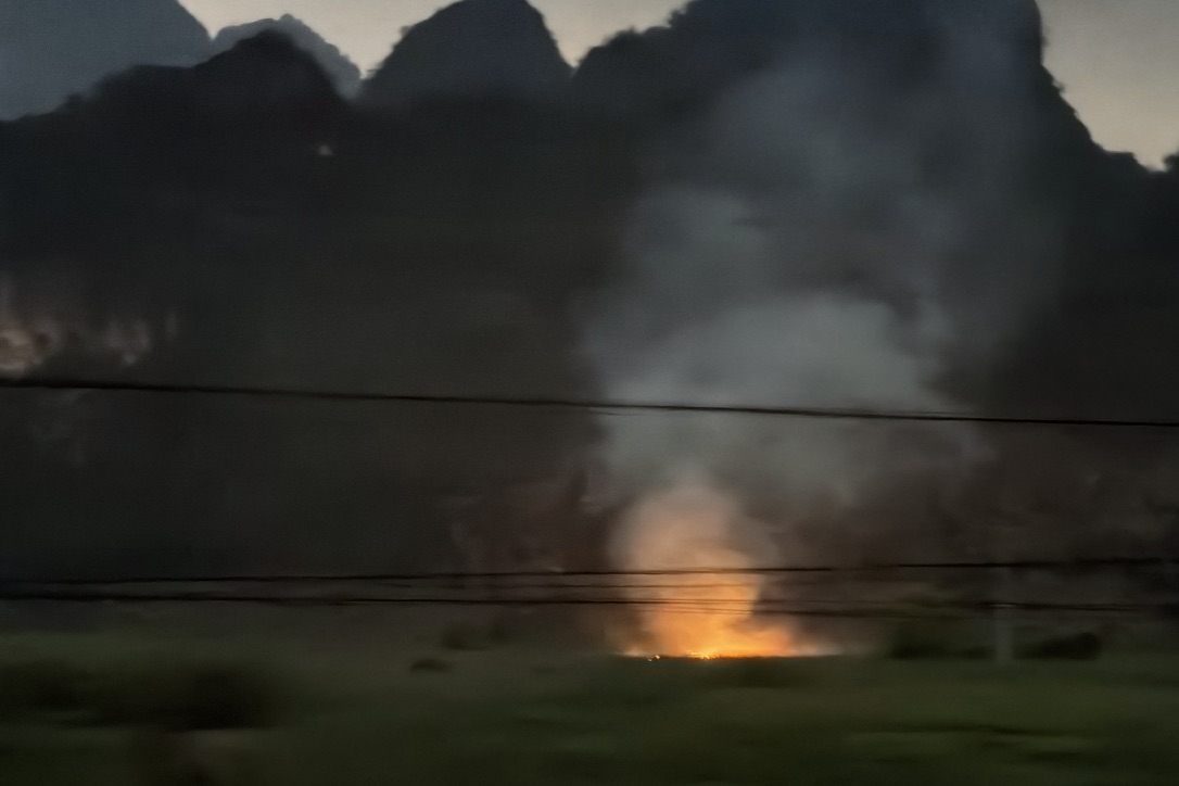 路的两边有不少人在烧甘蔗叶,农田里火光冲天,有的火势规模很大。