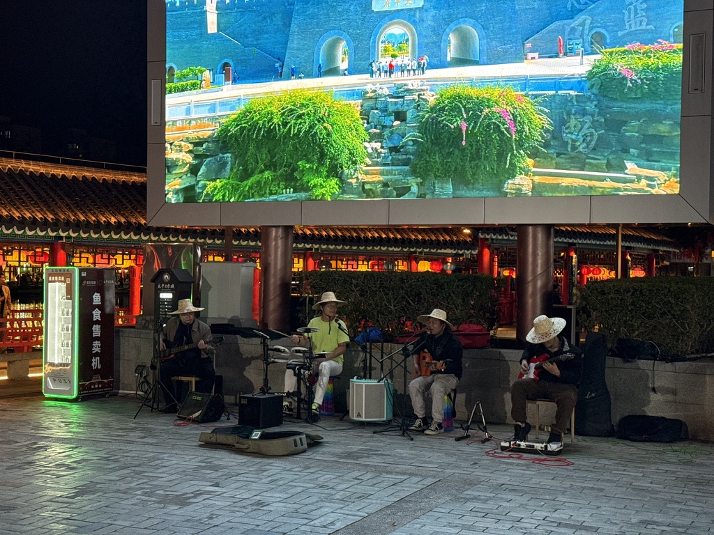 古城里有一个乐队在演出,唱的是beyond的歌,看起来非常的广西