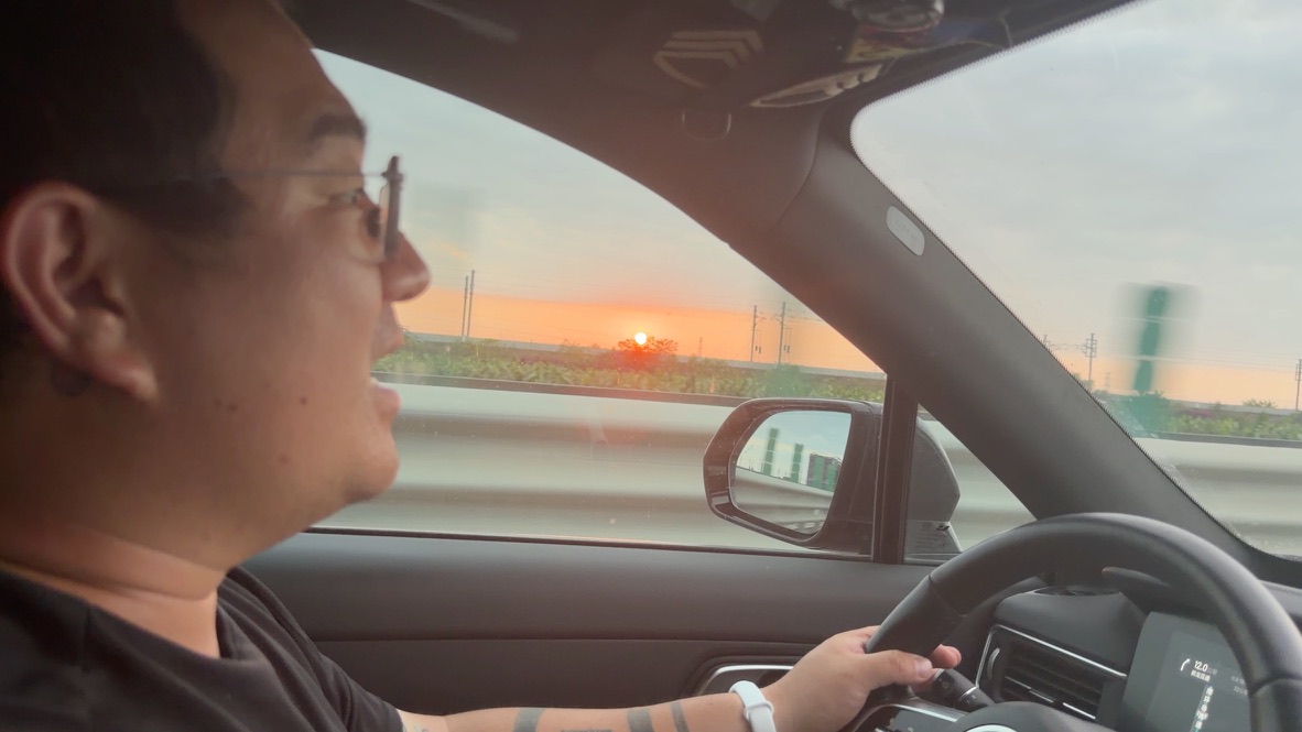 环岛高速的西段，落日进行时。恙儿让我张开嘴，想拍一段吃太阳的视频。